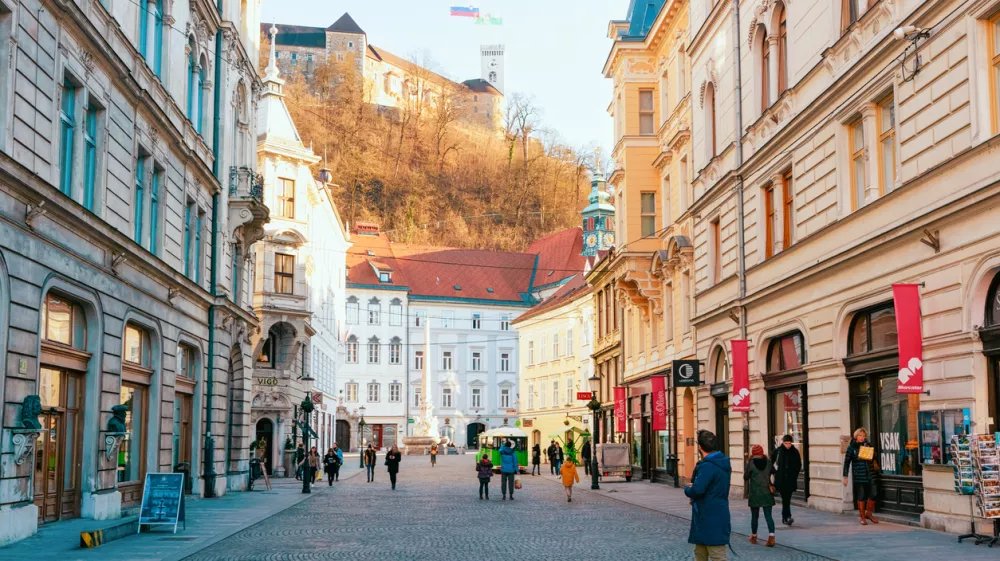 Ljubljana, Slovenia - January 15, 2019: Tourists on Stritarjeva Ulica Street and cityscape of Ljubljana old town with Castle, Slovenia, Europe. People in Slovenian city view in winter. Urban capital.