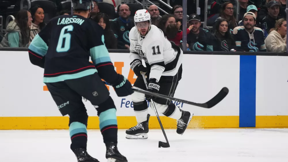 Los Angeles Kings center Anze Kopitar moves the puck against Seattle Kraken defenseman Adam Larsson (6) during the second period of an NHL hockey game Monday, April 13, 2026, in Seattle. (AP Photo/Lindsey Wasson)