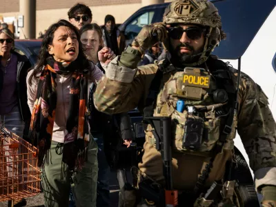 Community members and rapid responders yell at federal immigration enforcement agents after they detained two men outside a Home Depot in Evanston in Evanston, Ill., Wednesday, Dec. 17, 2025. (Ashlee Rezin/Chicago Sun-Times via AP)