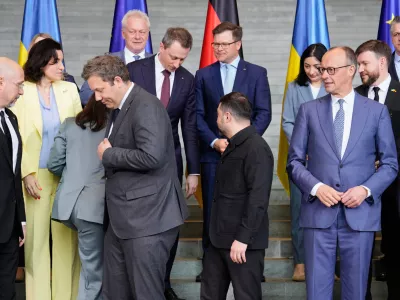 German chancellor Friedrich Merz, right, watches beside Ukraine's President Volodymyr Zelenskyy, to his Finance Minister Lars Klingbeil, left, at a family photo during German-Ukrainian government consultations in Berlin Germany, Tuesday, April 14, 2026. (AP Photo/Markus Schreiber)