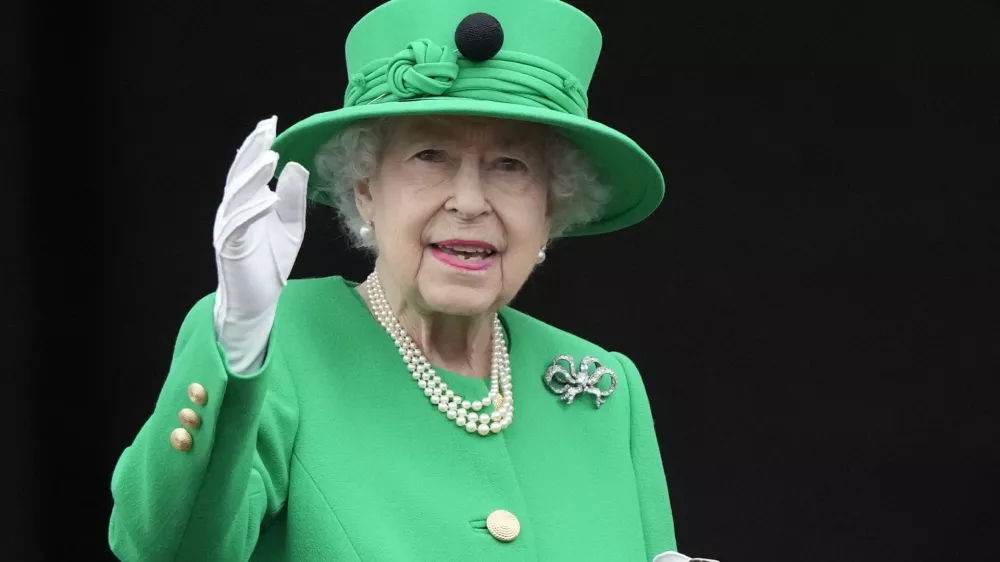 Queen Elizabeth II waves to the crowd during the Platinum Jubilee Pageant at the Buckingham Palace in London, Sunday, June 5, 2022, on the last of four days of celebrations to mark the Platinum Jubilee. The pageant will be a carnival procession up The Mall featuring giant puppets and celebrities that will depict key moments from the Queen Elizabeth II's seven decades on the throne. (AP Photo/Frank Augstein, Pool)
