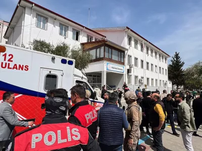 Turkish security forces and emergency staff stand in the courtyard of a secondary school where an assailant opened fire, in Kahramanmaras, Turkey, Wednesday, April 15, 2026, (IHA via AP)
