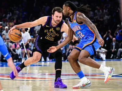 Los Angeles Lakers forward/guard Luka Dončić (77) drives against Oklahoma City Thunder guard Cason Wallace (22) during the first half of an NBA basketball game Thursday, April. 2, 2026, in Oklahoma City. (AP Photo/Gerald Leong)