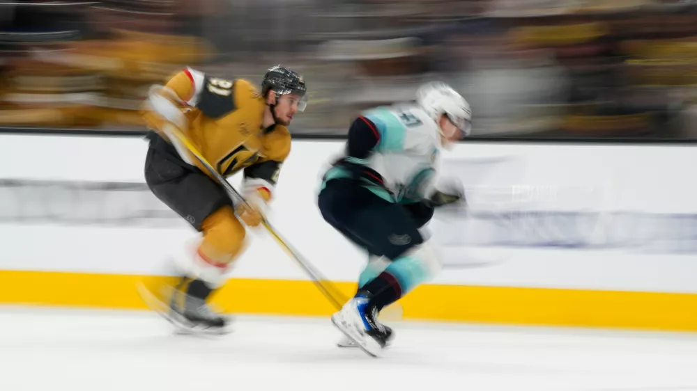Vegas Golden Knights center Brett Howden, left, and Seattle Kraken defenseman Ryker Evans (41) battle for the puck during the second period of an NHL hockey game Wednesday, April 15, 2026, in Las Vegas. (AP Photo/John Locher)