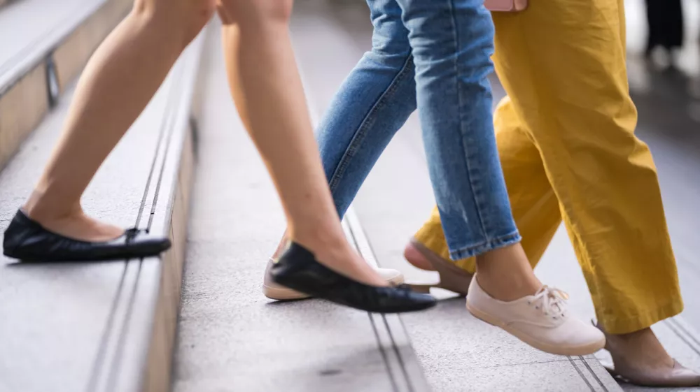 Close up of legs and shoes walking on street in the city