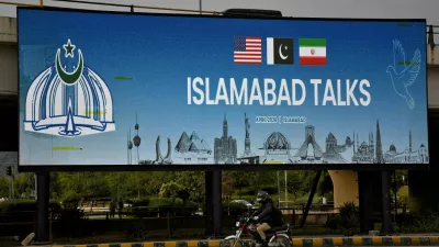 FILE PHOTO: A man rides his motorbike past a billboard installed alongside a road as Pakistan prepares to host the U.S. and Iran for peace talks, in Islamabad, Pakistan, April 10, 2026. REUTERS/Waseem Khan/File Photo