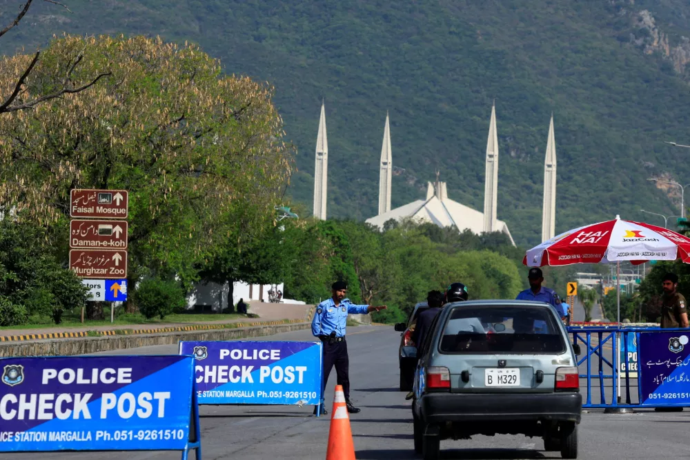 A police officer gestures to a vehicle at a check post along a road near Faisal Masjid, as Pakistan prepares to host the U.S. and Iran for the second phase of peace talks in Islamabad, Pakistan April 19, 2026. REUTERS/Akhtar Soomro
