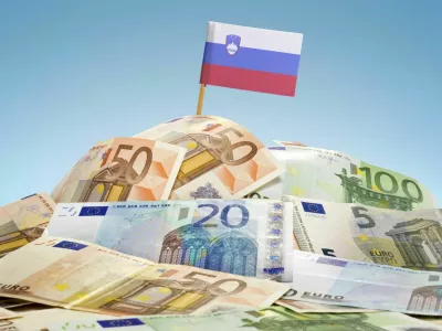 The national flag of Slovenia sticking in a pile of mixed european banknotes.(series)