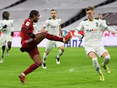 07 January 2022, Bavaria, Munich: Munich's Serge Gnabry (L) and Moenchengladbach's Luca Netz battle for the ball during the German Bundesliga soccer match between Bayern Munich and Borussia Moenchengladbach at Allianz Arena. Photo: Sven Hoppe/dpa - IMPORTANT NOTICE: DFL and DFB regulations prohibit any use of photographs as image sequences and/or quasi-video.