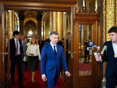 Prime Minister-elect Peter Magyar, the Tisza Party's leader, center, leaves the preparatory meeting for the inaugural session of the Parliament at the Parliament building in Budapest, Hungary, Friday, April 17, 2026. (Robert Hegedus/MTI via AP)