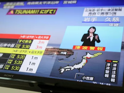 A television screen shows a news report on Japan Meteorological Agency's tsunami warning, saying it expected tsunami waves of up to 3 meters (9.84 feet) to reach large coastal areas in northern Japan after an earthquake with a preliminary magnitude of 7.4 struck off the northeastern coast of Japan, in Tokyo, Japan April 20, 2026.REUTERS/Issei Kato