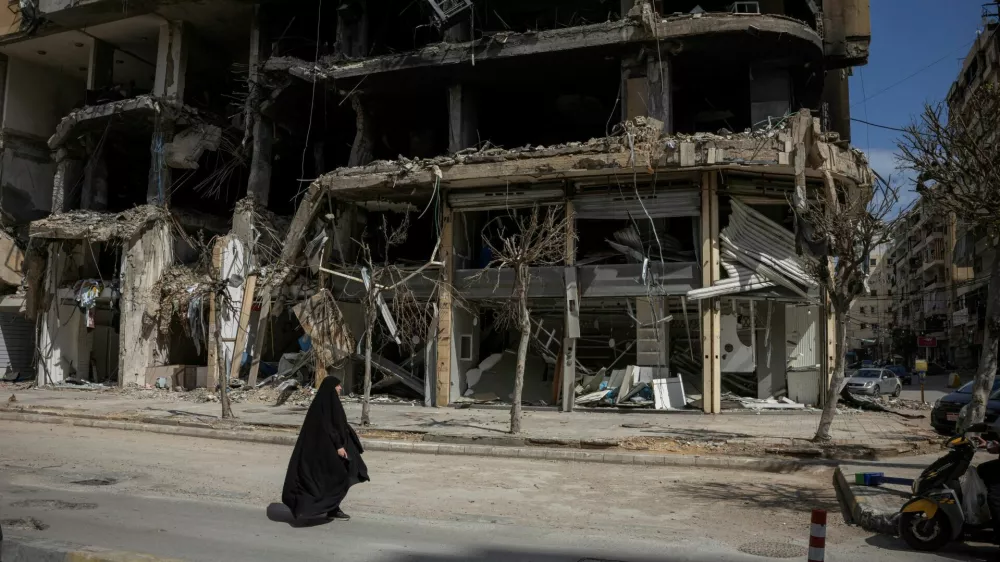 A woman walks past damaged buildings amid a 10-day ceasefire between Lebanon and Israel, in the southern suburbs of Beirut, Lebanon, April 20, 2026. REUTERS/Marko Djurica   TPX IMAGES OF THE DAY