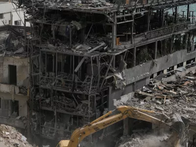 FILE - An excavator removes rubble from destroyed buildings that were hit by Israeli airstrikes on Thursday, as rescuers search for victims in the city of Tyre, southern Lebanon, Saturday, April 18, 2026. (AP Photo/Bilal Hussein, File)