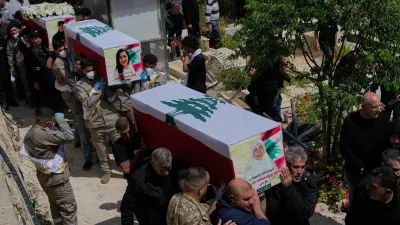 Mourners carry the coffins of civilians who were killed in the war between Hezbollah and Israel during a mass funeral in Bazouriyeh village, south Lebanon, Monday, April 20, 2026. (AP Photo/Mohammed Zaatari)
