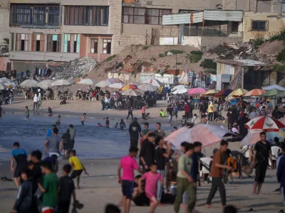 Palestinians gather by the sea on Gaza City's beach, Sunday, April 19, 2026. (AP Photo/Jehad Alshrafi)