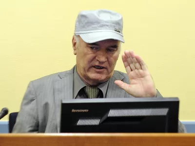 Former Bosnian Serb General Ratko Mladic salutes in the court room during his initial appearance at the U.N.'s Yugoslav war crimes tribunal in The Hague, Netherlands, Friday, June 3, 2011.Mladic's appearance Friday at the Yugoslav war crimes tribunal in The Hague is his first public appearance since he went into hiding nearly 16 years ago, when he was indicted for genocide and war crimes committed in the 1992-95 Bosnian war. (AP Photo/Martin Meissner, Pool)