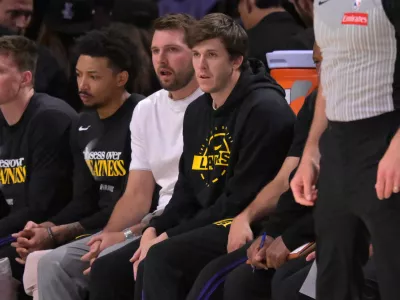 Apr 21, 2026; Los Angeles, California, USA; Los Angeles Lakers guard Luka Docic (77) and guard Austin Reaves (15) look on from the bench in the first half of game two of the first round of the 2026 NBA Playoffs against the Houston Rockets at Crypto.com Arena. Mandatory Credit: Jayne Kamin-Oncea-Imagn Images