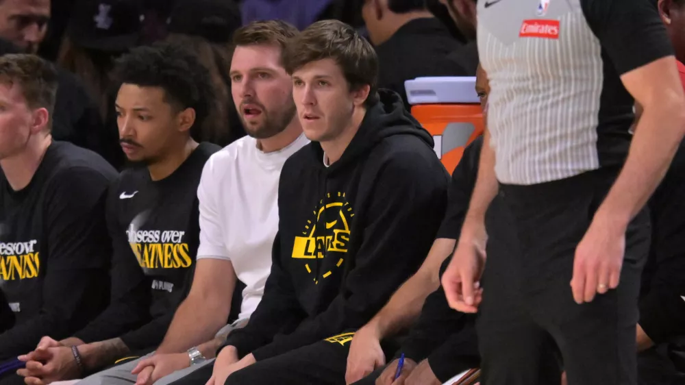 Apr 21, 2026; Los Angeles, California, USA; Los Angeles Lakers guard Luka Docic (77) and guard Austin Reaves (15) look on from the bench in the first half of game two of the first round of the 2026 NBA Playoffs against the Houston Rockets at Crypto.com Arena. Mandatory Credit: Jayne Kamin-Oncea-Imagn Images