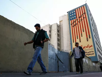 People walk past an anti-U.S. mural on a building, amid a ceasefire between U.S. and Iran, in Tehran, Iran, April 22, 2026. Majid Asgaripour/WANA (West Asia News Agency) via REUTERS ATTENTION EDITORS - THIS PICTURE WAS PROVIDED BY A THIRD PARTY