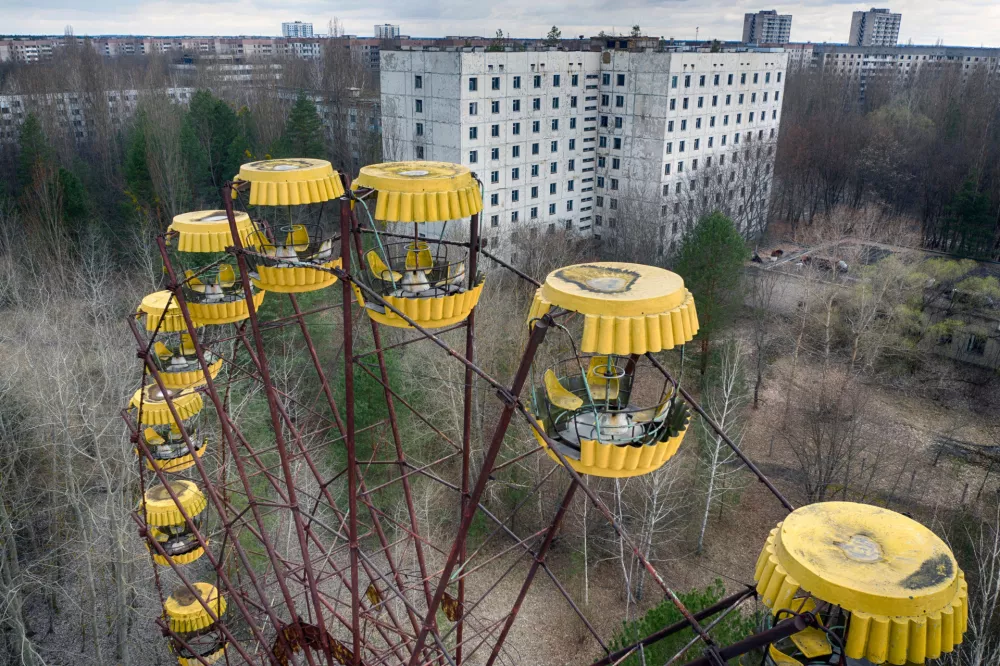 FILE - An abandoned Ferris wheel stands in a city park, April 15, 2021, in the abandoned town of Pripyat, Ukraine, once home to workers and their families whose lives were connected to the nearby Chernobyl nuclear power plant. (AP Photo/Efrem Lukatsky, File)