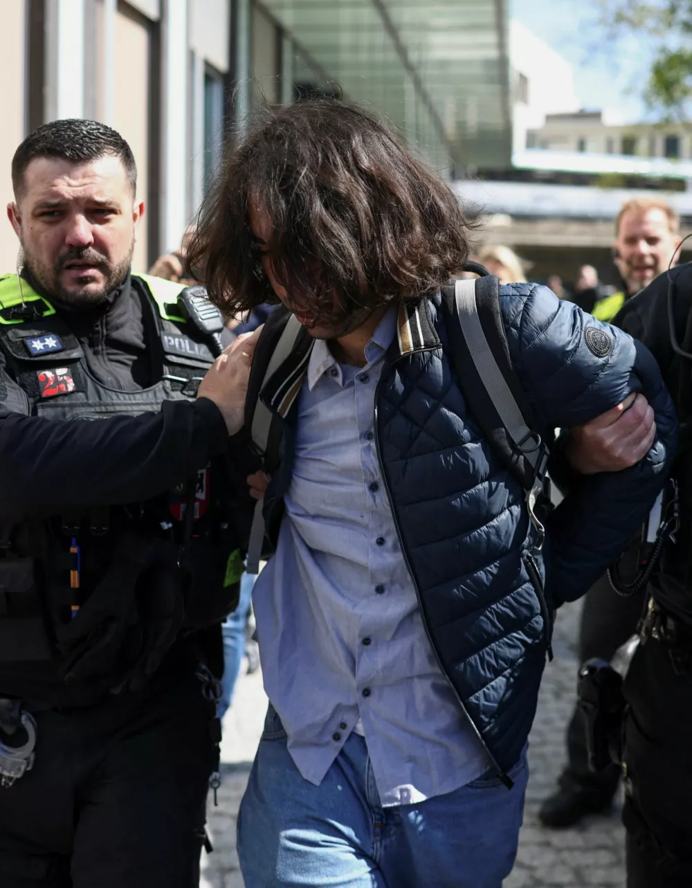 A person suspected of throwing red substance on Reza Pahlavi, the exiled son of Iran's last shah and an Iranian opposition figure, is detained in Berlin, Germany, April 23, 2026. REUTERS/Liesa JohannssenвЂЁвЂЁ