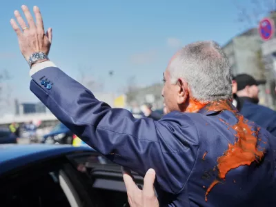Iran's Reza Pahlavi, exiled son of Shah Reza Pahlavi, waves to supporters after he was attacked with a red fluid following a news conference in Berlin, Germany, Thursday, April 23, 2026. (AP Photo/Markus Schreiber)