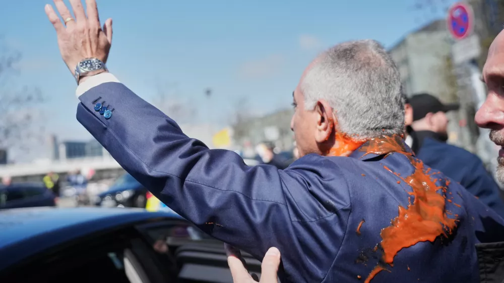 Iran's Reza Pahlavi, exiled son of Shah Reza Pahlavi, waves to supporters after he was attacked with a red fluid following a news conference in Berlin, Germany, Thursday, April 23, 2026. (AP Photo/Markus Schreiber)