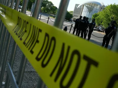 Police officers gather as people take part in a protest outside the Donald J. Trump Institute of Peace in Washington, D.C., U.S., April 23, 2026. REUTERS/Ken Cedeno