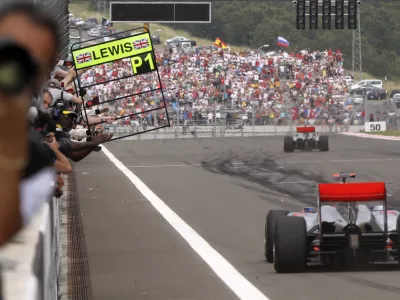 McLaren Mercedes driver Lewis Hamilton of Britain is seen in background after crossing the finish line to win the Turkish Formula One Grand Prix at the Istanbul Park circuit racetrack, in Istanbul, Turkey, Sunday, May 30, 2010. In foreground is seen second place McLaren Mercedes driver Jenson Button of Britain. (AP Photo/Thanassis Stavrakis)