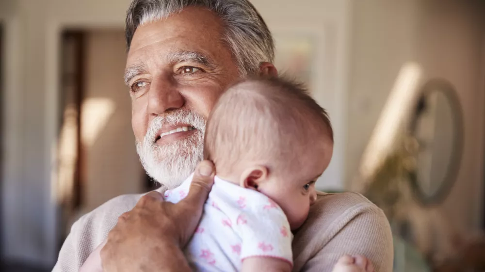 Hispanic grandfather holding his baby grandson, head and shoulders, close up
