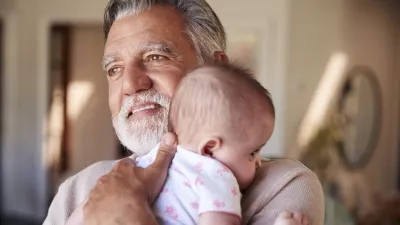 Hispanic grandfather holding his baby grandson, head and shoulders, close up