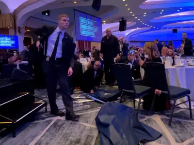 A Secret Service agent unholsters his gun, shortly after U.S. President Donald Trump was evacuated, after a man opened fire with a shotgun on security personnel outside the room during the annual White House Correspondents' Association dinner in Washington, D.C., U.S., April 25, 2026, in this screengrab from a video. REUTERS/Bo Erickson