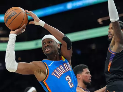 Oklahoma City Thunder guard Shai Gilgeous-Alexander (2) passes the ball as Phoenix Suns guard Jalen Green (4) defends during the second half of Game 3 of a first-round NBA playoffs basketball series, Saturday, April 25, 2026, in Phoenix. (AP Photo/Ross D. Franklin)