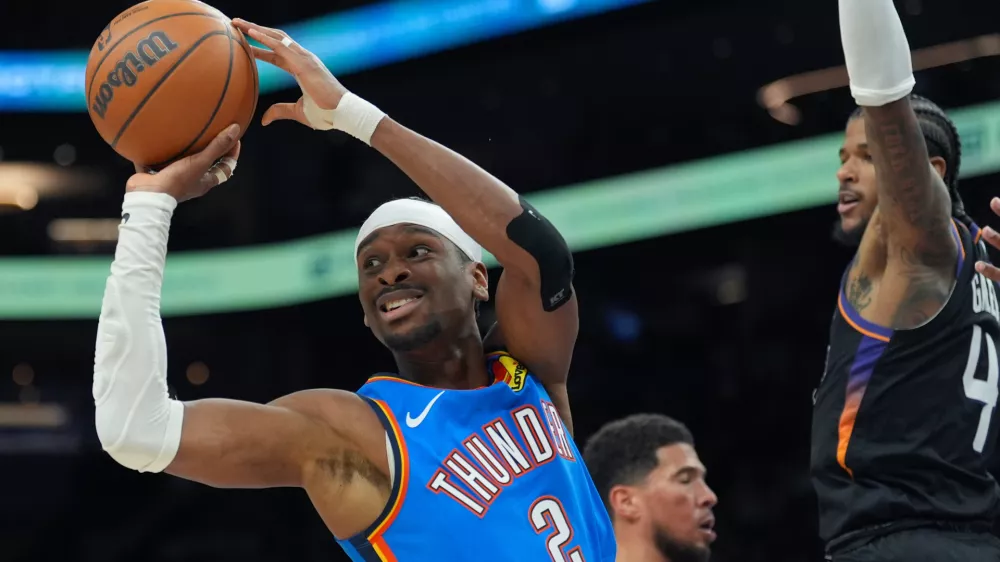 Oklahoma City Thunder guard Shai Gilgeous-Alexander (2) passes the ball as Phoenix Suns guard Jalen Green (4) defends during the second half of Game 3 of a first-round NBA playoffs basketball series, Saturday, April 25, 2026, in Phoenix. (AP Photo/Ross D. Franklin)
