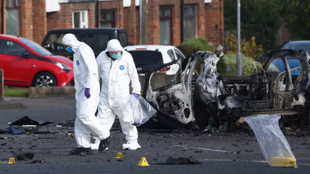 Forensic investigators inspect the site of a car bomb that exploded outside Dunmurry police station in South Belfast, Sunday, April 26, 2026. (AP Photo/Peter Morrison)
