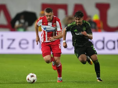 Red Star's Timi Max Elsnik, left, challenges for the ball with Celtic's Sebastian Tounekti during the Europa League soccer match between Red Star and Celtic at the Rajko Mitic Stadium in Belgrade, Serbia, Wednesday, Sept. 24, 2025. (AP Photo/Darko Vojinovic)