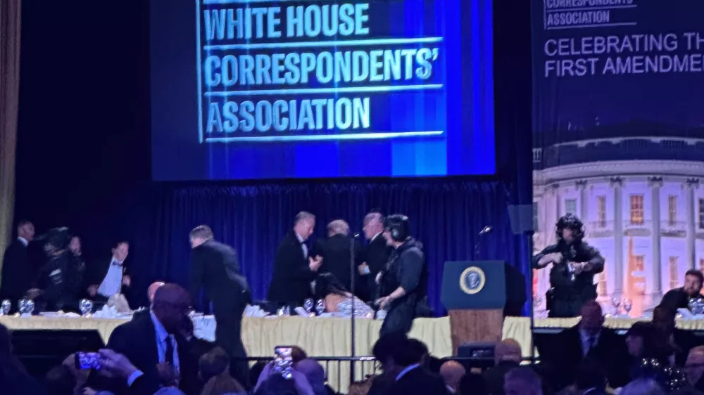 U.S. Secret Service agents surround President Donald Trump as he is taken from the stage after a shooting incident outside the ballroom during the White House Correspondents Dinner, Saturday, April 25, 2026, in Washington. (AP Photo/Alex Brandon)