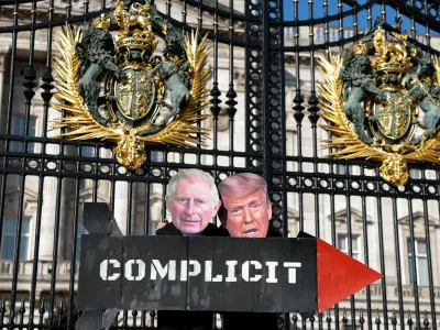 People from The Stop Trump Coalition dressed as Britain's King Charles and U.S. President Donald Trump hold a prop missile outside Buckingham Palace as the group opposes the bombing of Iran and calls on the UK to stop allowing use of UK military bases by U.S. aircraft, in London, Britain, April 27, 2026. REUTERS/Hannah McKay