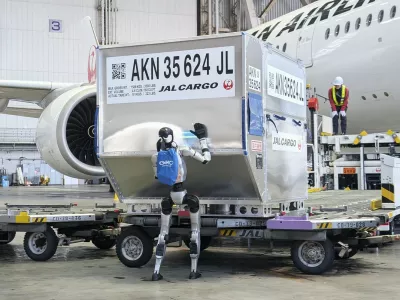 A humanoid robot pushes a cargo container during a media demonstration at Haneda airport in Tokyo on April 27, 2026. Japan Airlines will test the use of such robots at the airport from May, as the airline aims for their practical use in ground handling tasks, such as cargo loading and unloading, in 2028 amid a chronic manpower shortage.,Image: 1094715965, License: Rights-managed, Restrictions:, Model Release: no