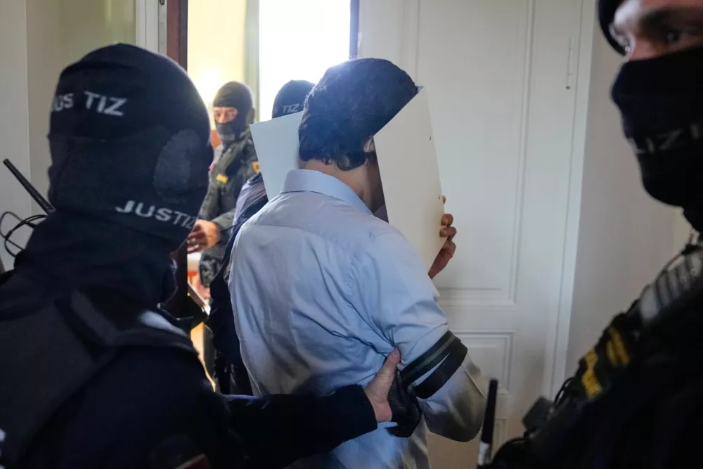 A defendant hiding his face behind file folders on the way to the courtroom in the District Court in Wiener Neustadt, Austria, where two terror suspects will stand trial Tuesday, one for&nbsp;plotting&nbsp;to carry out an attack on one of superstar singer Taylor Swift's concerts in Vienna in August 2024 and pledging allegiance to the Islamic State group, Tuesday, April 28, 2026. (AP Photo/Matthias Schrader)
