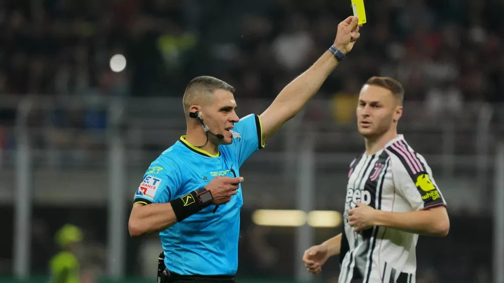 Referee Simone Sozza shows the yellow card during the Serie A soccer match between AC Milan and Juventus, in Milan, Italy, Sunday, April 26, 2026. (Alessio Morgese/LaPresse via AP)