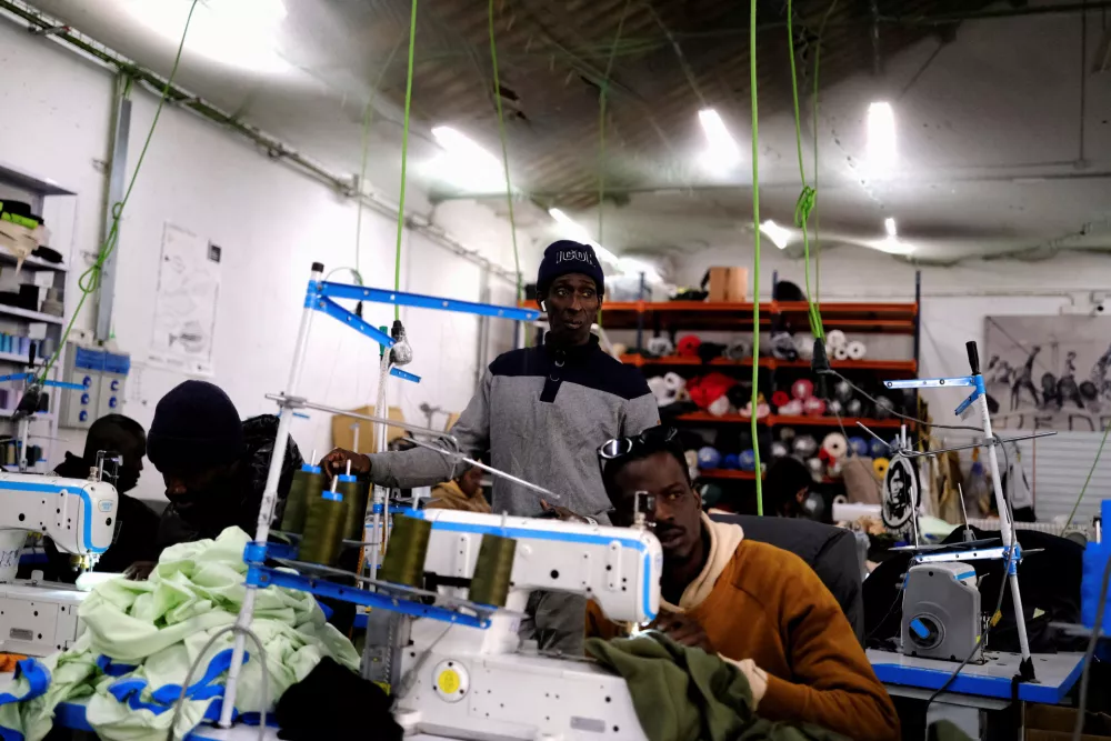 FILE PHOTO: Former street vendor and tailor immigrants sew clothes to sell the collections in a Top Manta shop in Barcelona's Raval district, Spain December 5, 2025. "Top Manta" is the name given to street vendors in Spain, where mantas (blankets) are used to display goods. REUTERS/Nacho Doce/File Photo