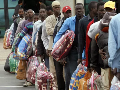 African would-be immigrants wait in line to board a plane to Mali at the airport in Oujda, in northern Morocco, October 13, 2005. Morocco, under pressure to staunch an inrush of immigrants into Spain, flew 139 illegal migrants back to Mali on Wednesday and vowed to continue with the mass deportations despite sharp criticism from the United Nations.REUTERS/Andrea Comas