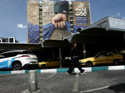 A woman walks past a billboard with a graphic design about the Strait of Hormuz on a building, amid a ceasefire between U.S. and Iran, in Tehran, Iran, April 27, 2026. Majid Asgaripour/WANA (West Asia News Agency) via REUTERS ATTENTION EDITORS - THIS PICTURE WAS PROVIDED BY A THIRD PARTY