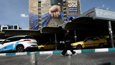 A woman walks past a billboard with a graphic design about the Strait of Hormuz on a building, amid a ceasefire between U.S. and Iran, in Tehran, Iran, April 27, 2026. Majid Asgaripour/WANA (West Asia News Agency) via REUTERS ATTENTION EDITORS - THIS PICTURE WAS PROVIDED BY A THIRD PARTY