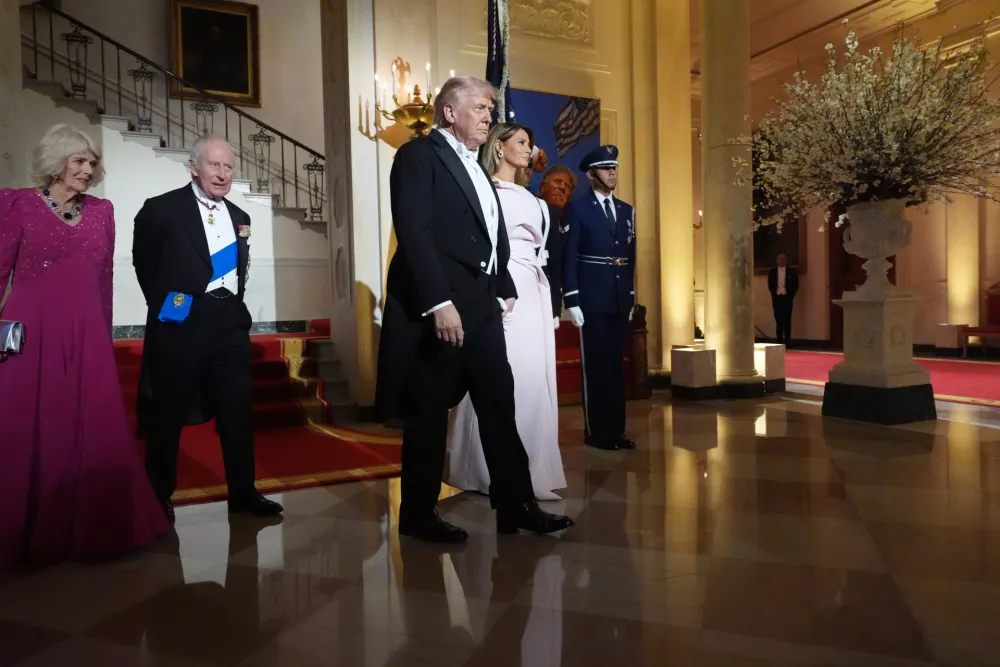 President Donald Trump and first lady Melania Trump walk with Britain's King Charles III and Queen Camilla at the Grand Staircase after posing for a photo in the Grand Foyer of the White House during a State Dinner Tuesday, April 28, 2026, in Washington. (AP Photo/Alex Brandon)