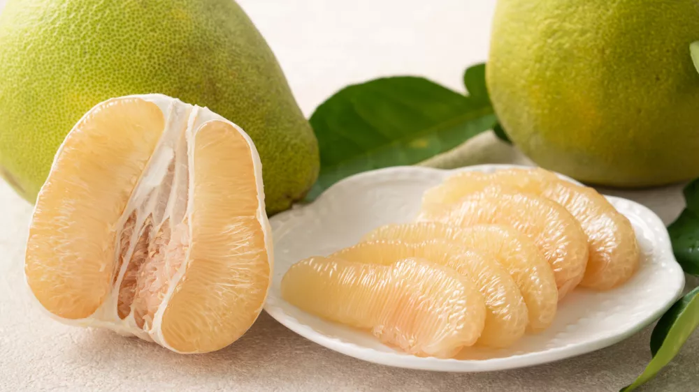 Fresh peeled pomelo with leaf on white table background for Mid-Autumn Festival fruit. / Foto: Insjoy