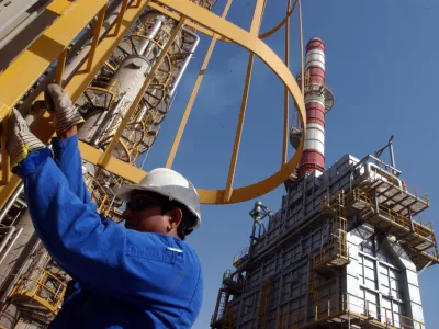 FILE - An oil technician climbs down a tower at a refinery in Jebel Ali, United Arab Emirates, about 30 kilometers (18 miles) south of Dubai, in March 2004. (AP Photo/Kamran Jebreili, File)