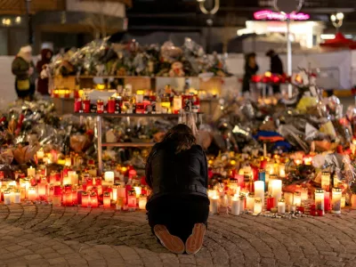 FILE PHOTO: A woman lights a candle at a makeshift memorial outside the "Le Constellation" bar, after a deadly fire and explosion during a New Year's Eve party, in the upscale ski resort of Crans-Montana in southwestern Switzerland, January 5, 2026. REUTERS/Umit Bektas/File Photo / Foto: Umit Bektas