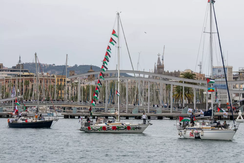 Boats carrying activists and humanitarian aid for Palestinians in Gaza reposition in the port during a symbolic send-off as part of the Global Sumud Flotilla, in Barcelona, Spain, Sunday, April 12, 2026. (AP Photo/Joan Mateu Parra)